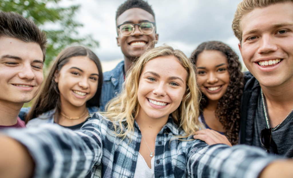 A group of teens standing together taking a selfie